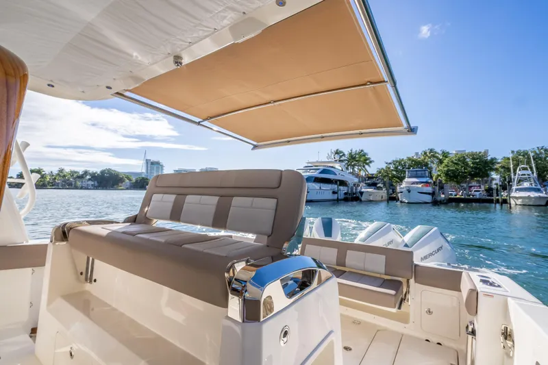 Slide: The Image of 2026 Boston Whaler 420 Outrage boat with seating and canopy on a sunny day. - 63