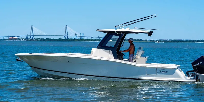 Slide: The Image of 2026 Scout 288 LXF boat cruising on a calm lake with a Mercury engine. - 1