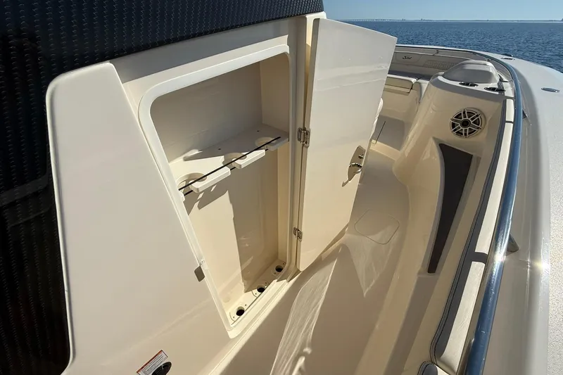 Slide: The Image of 2026 Scout 288 LXF boat storage compartment open on deck, ocean view. - 21