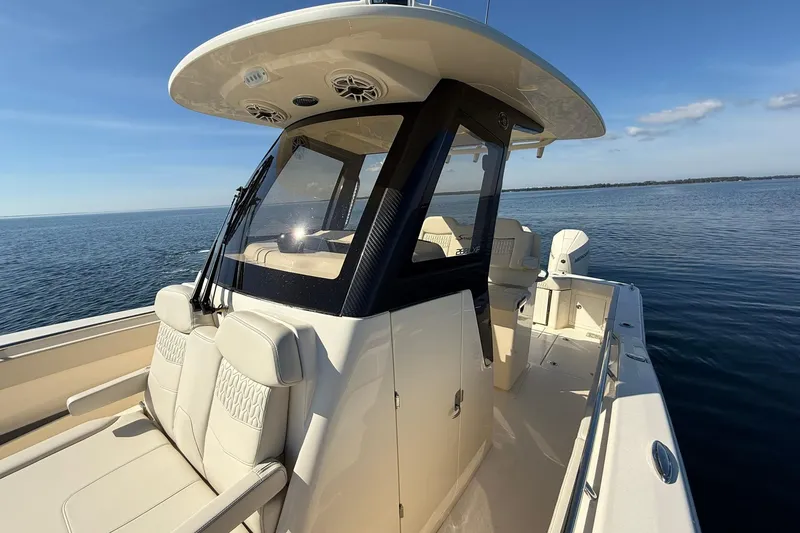 Slide: The Image of 2026 Scout 288 LXF boat on calm water, showcasing sleek design and luxurious seating. - 22