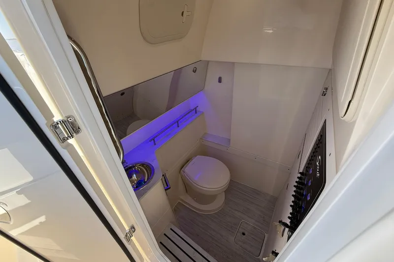 Slide: The Image of 2026 Scout 288 LXF boat interior bathroom with modern fixtures and blue accent lighting. - 23