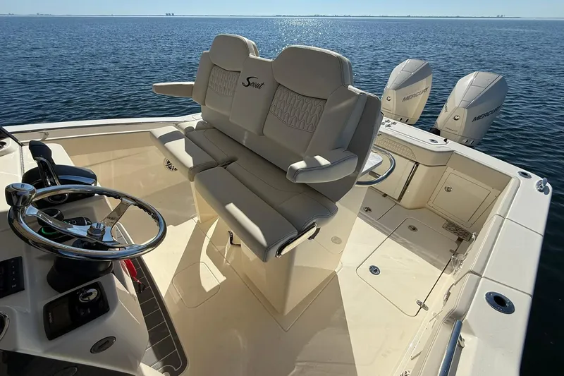 Slide: The Image of 2026 Scout 288 LXF boat interior with helm, seating, and triple Mercury engines. - 26