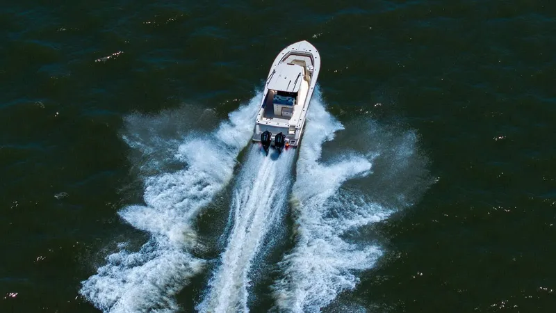 Slide: The Image of 2026 Scout 288 LXF boat cruising on a calm lake under clear skies. - 3