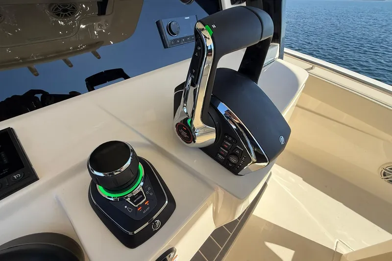 Slide: The Image of 2026 Scout 288 LXF boat controls with joystick and throttle, overlooking the ocean. - 30