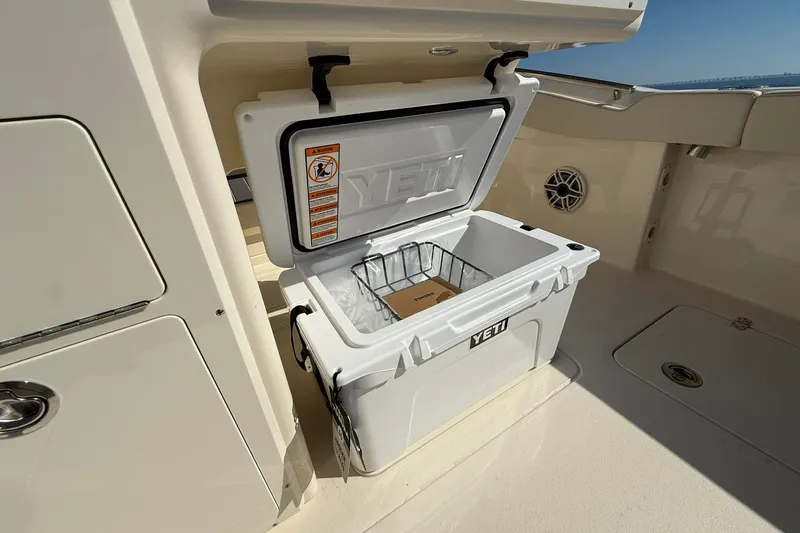 Slide: The Image of Open YETI cooler on 2026 Scout 288 LXF boat deck, showcasing storage space. - 37