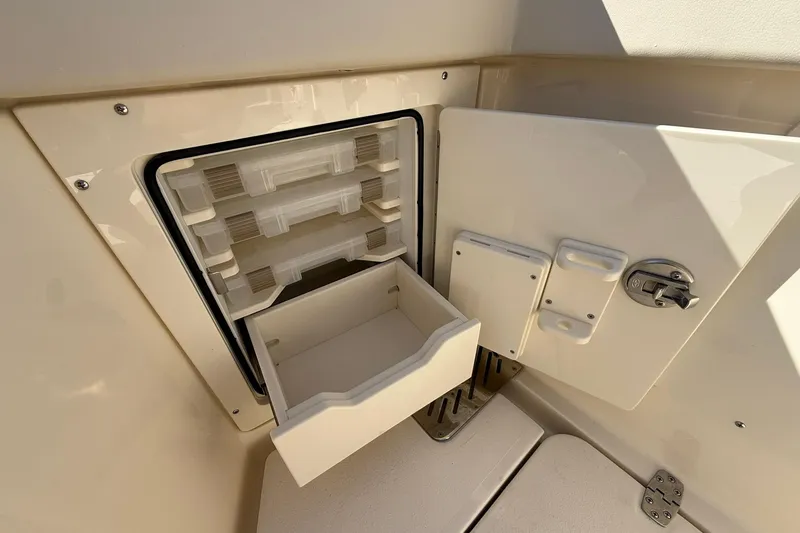 Slide: The Image of 2026 Scout 288 LXF boat storage compartment with open drawer and latch. - 41