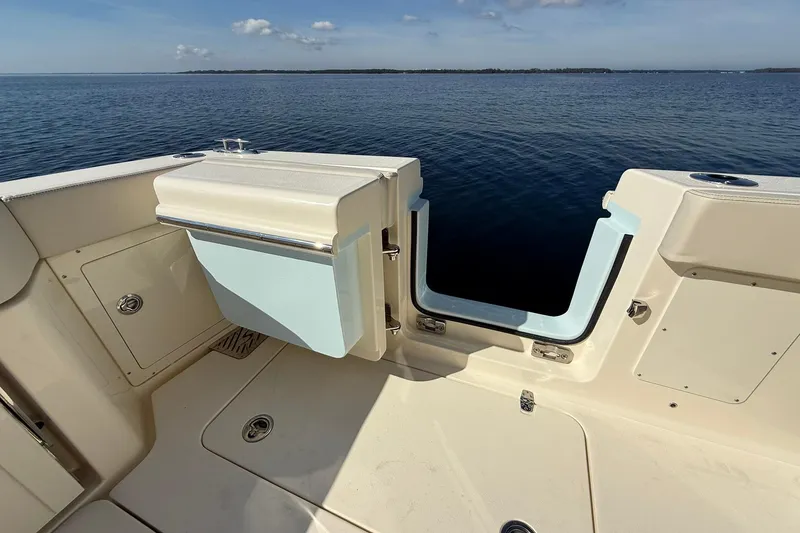 Slide: The Image of 2026 Scout 288 LXF boat deck with open transom door, overlooking calm water. - 42