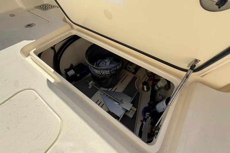 Slide: The Image of Open storage compartment on 2026 Scout 288 LXF boat, showing equipment and supplies. - 44