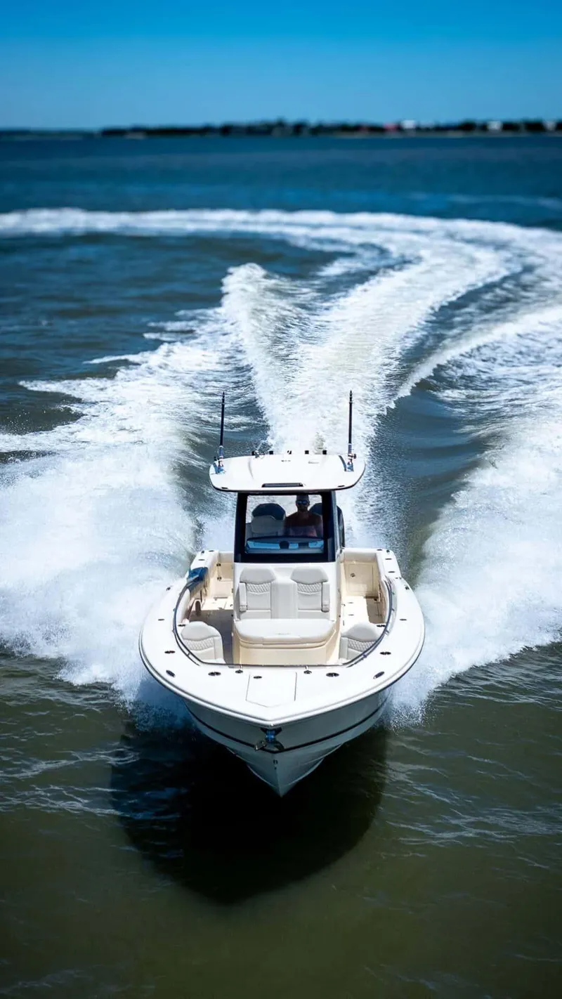 Slide: The Image of 2026 Scout 288 LXF boat interior with seating and cup holders on calm water. - 8