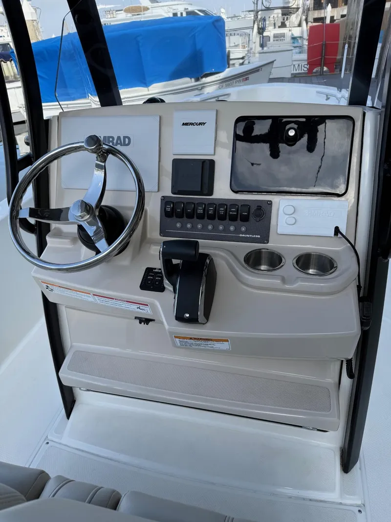 Slide: The Image of Control panel of 2024 Boston Whaler 250 Dauntless boat with steering wheel and controls. - 4