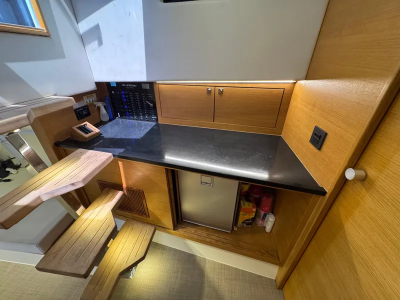 Slide: The Image of Interior of 2021 De Antonio Yachts D42, featuring a sleek kitchenette with wooden accents. - 34