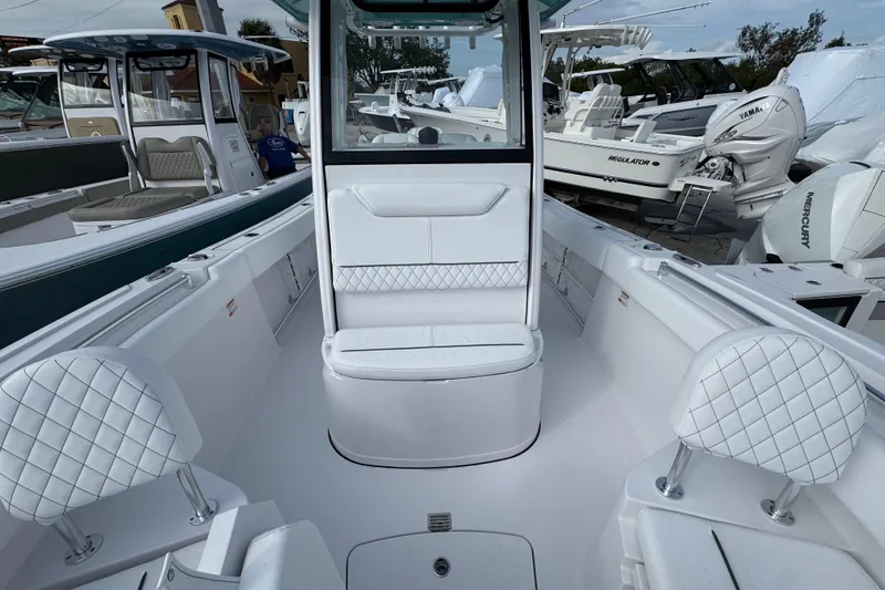Slide: The Image of 2026 Sportsman Heritage 231 Center Console boat interior with white seating and console. - 17