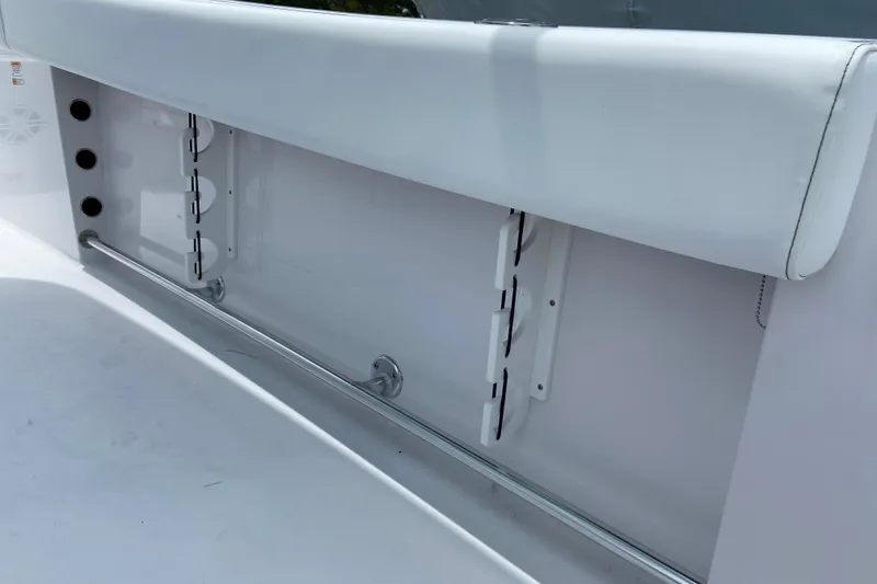 Slide: The Image of 2026 Sportsman Heritage 231 Center Console boat interior detail, featuring rod holders and cushioned seating. - 26
