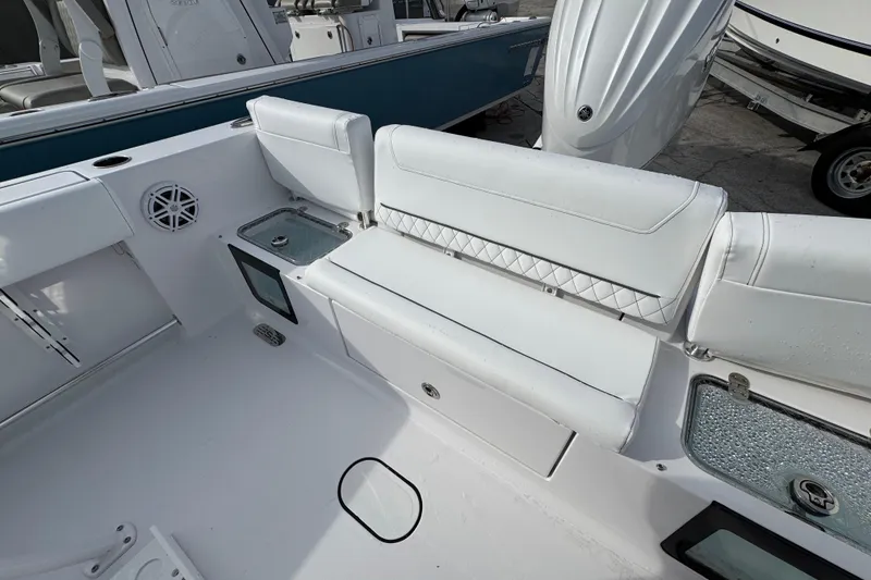 Slide: The Image of 2026 Sportsman Heritage 231 Center Console boat interior with white seating and storage compartments. - 6