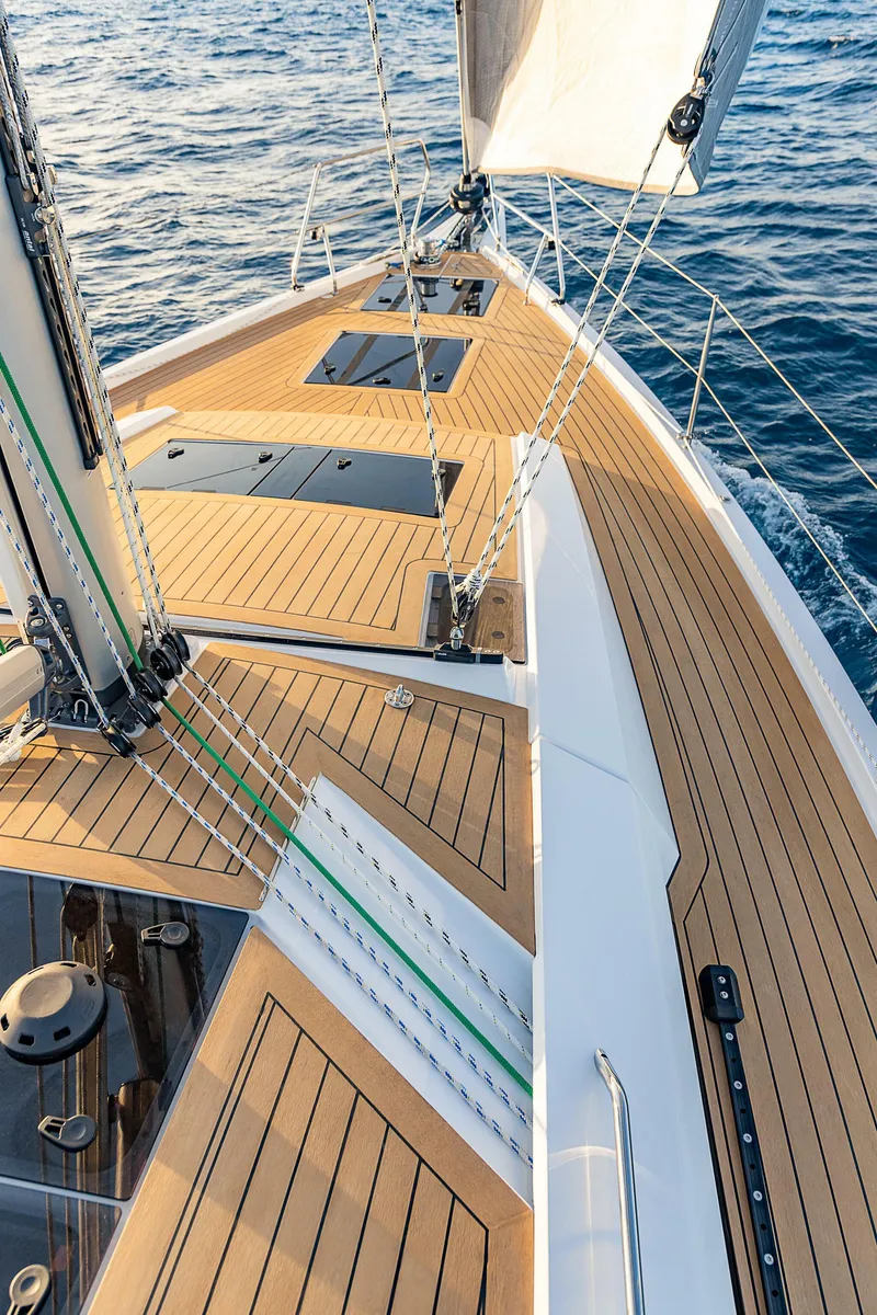 Slide: The Image of 2023 Hanse 460 sailboat deck with teak finish, sailing on open water. - 8