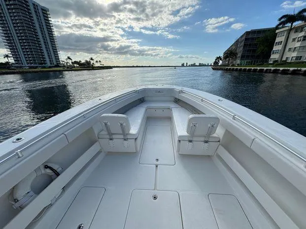 Slide: The Image of 2015 Invincible 39 Open Fisherman boat on calm water, urban skyline in background. - 11