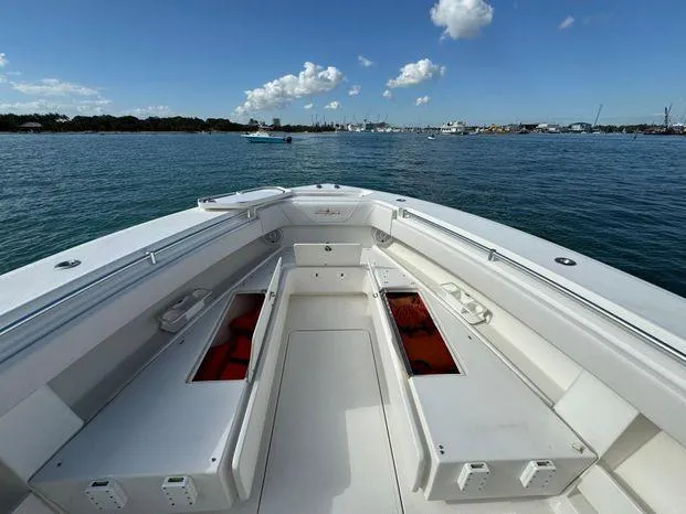 Slide: The Image of 2015 Invincible 39 Open Fisherman boat on calm water, clear sky, spacious deck. - 14