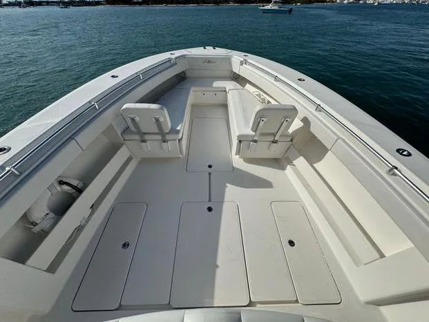 Slide: The Image of 2015 Invincible 39 Open Fisherman boat, spacious deck, white seating, calm waters. - 15