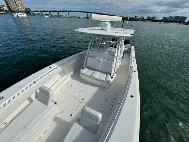 Slide: The Image of 2015 Invincible 39 Open Fisherman boat on calm water near a bridge and cityscape. - 17