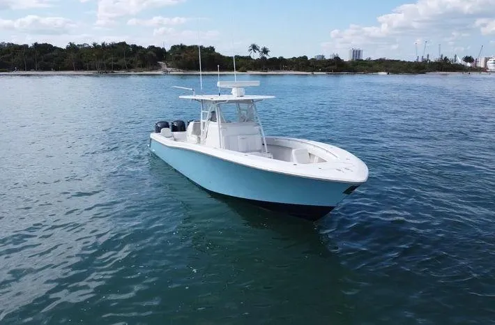 Slide: The Image of 2015 Invincible 39 Open Fisherman boat on calm water, clear sky background. - 2