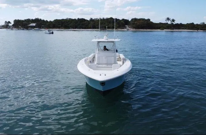 Slide: The Image of 2015 Invincible 39 Open Fisherman boat on calm water near a tropical shoreline. - 3