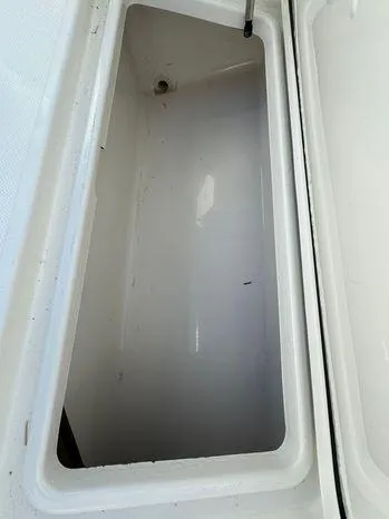 Slide: The Image of 2015 Invincible 39 Open Fisherman storage compartment, white interior, open lid. - 30