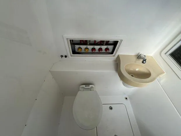 Slide: The Image of 2015 Invincible 39 Open Fisherman boat bathroom with toilet, sink, and control panel. - 45