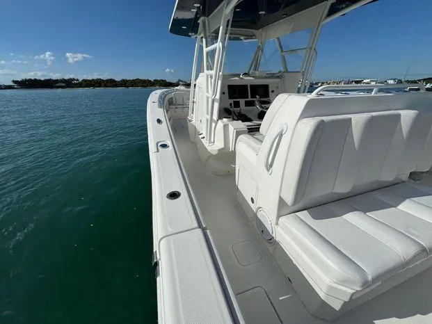 Slide: The Image of 2015 Invincible 39 Open Fisherman boat on calm water, showcasing sleek design and seating. - 6