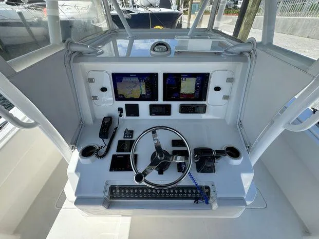 Slide: The Image of 2015 Invincible 39 Open Fisherman helm with dual displays and modern controls. - 8