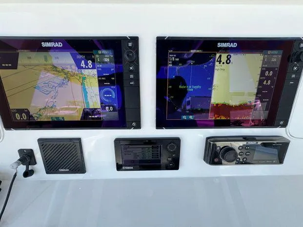 Slide: The Image of 2015 Invincible 39 Open Fisherman dashboard with dual Simrad displays and navigation equipment. - 9