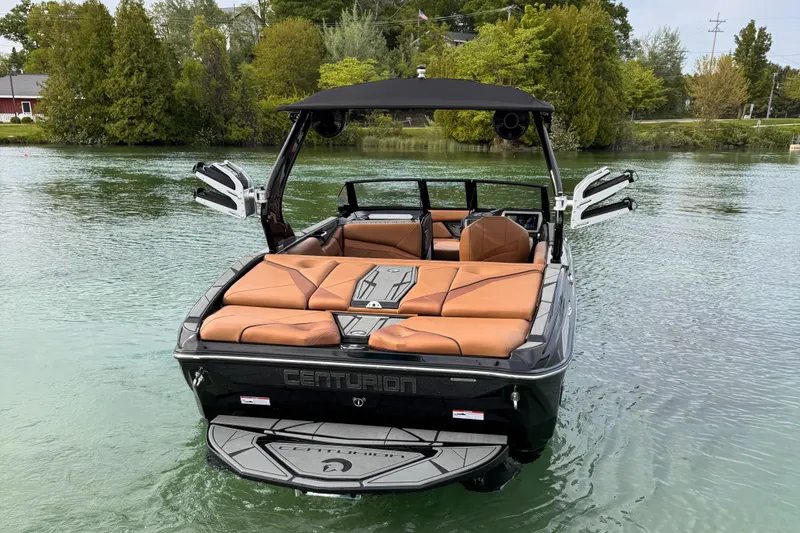 Slide: The Image of 2025 Centurion NV 213 boat with tan seating on a calm lake. - 6