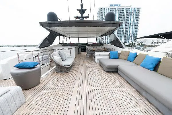 Slide: The Image of Luxurious 2017 Sanlorenzo SL106 yacht deck with modern seating and cityscape backdrop. - 2