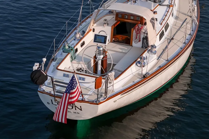 Slide: The Image of 1988 Hinckley Sou'wester 42 sailboat on calm water, displaying American flag. - 14