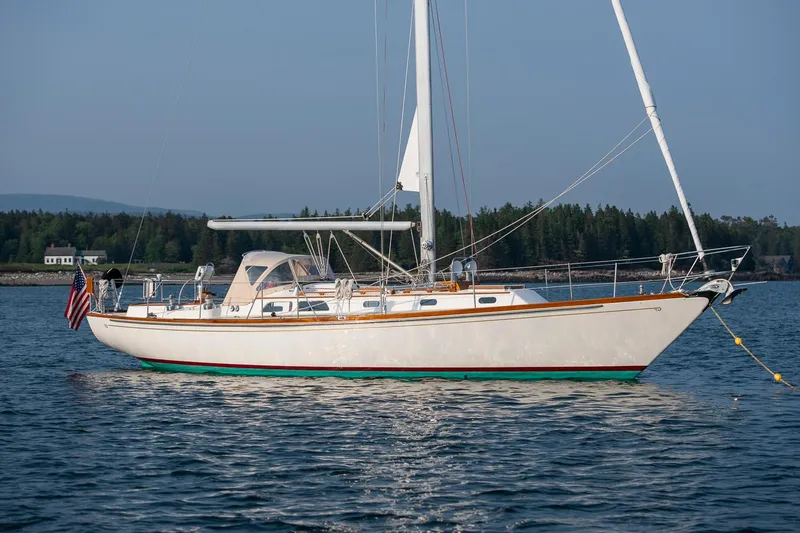 Slide: The Image of 1988 Hinckley Sou'wester 42 sailboat on calm water, with forested shoreline in background. - 2