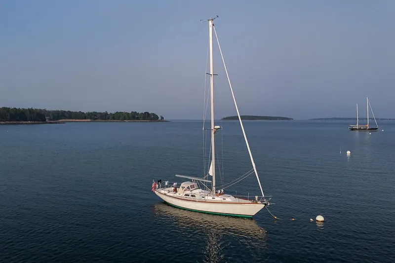 Slide: The Image of Sailboat Hinckley Sou'wester 42, 1988 model, anchored in calm waters with distant islands. - 3