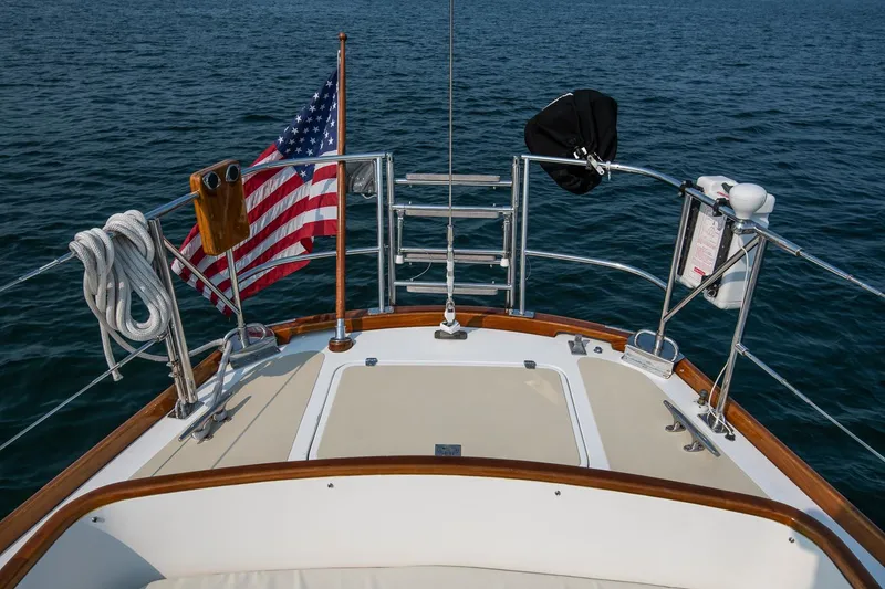 Slide: The Image of Hinckley Sou'wester 42 sailboat deck with American flag, 1988 model, on open water. - 32