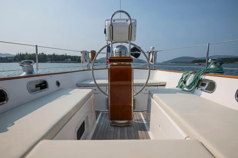 Slide: The Image of 1988 Hinckley Sou'wester 42 sailboat cockpit with steering wheel, seating, and scenic water view. - 33