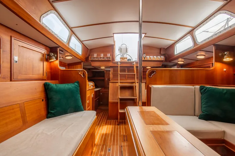 Slide: The Image of Interior of 1988 Hinckley Sou'wester 42 sailboat, featuring elegant woodwork and cozy seating. - 49