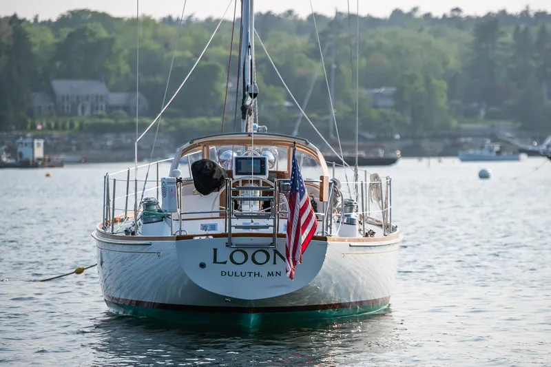 Slide: The Image of 1988 Hinckley Sou'wester 42 sailboat on calm water, displaying an American flag. - 7