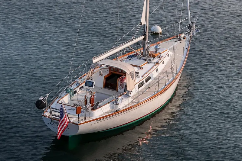 Slide: The Image of 1988 Hinckley Sou'wester 42 sailboat on calm water, displaying American flag. - 9