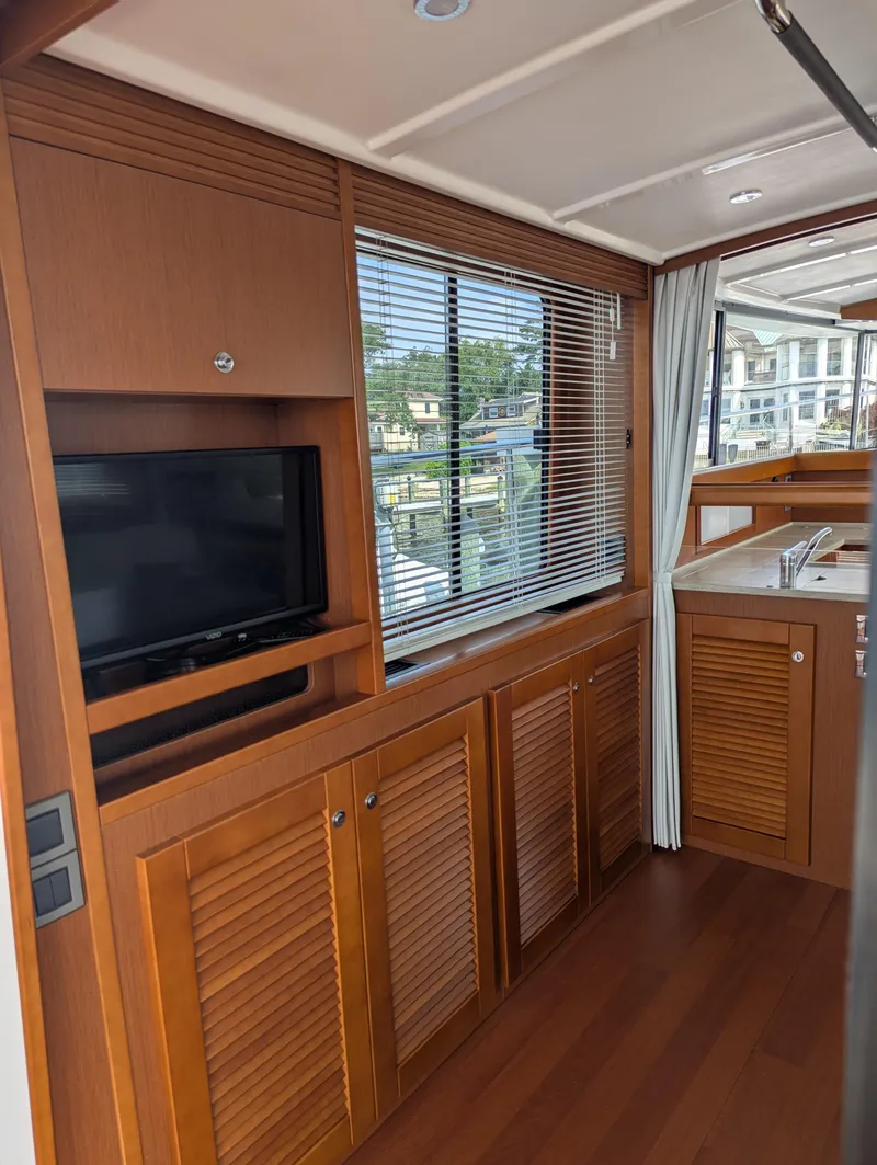 Slide: The Image of Interior of 2019 Beneteau Swift Trawler 44 with wood cabinetry and window blinds. - 11