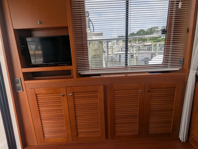 Slide: The Image of Interior of 2019 Beneteau Swift Trawler 44 with wooden cabinets and window blinds. - 19