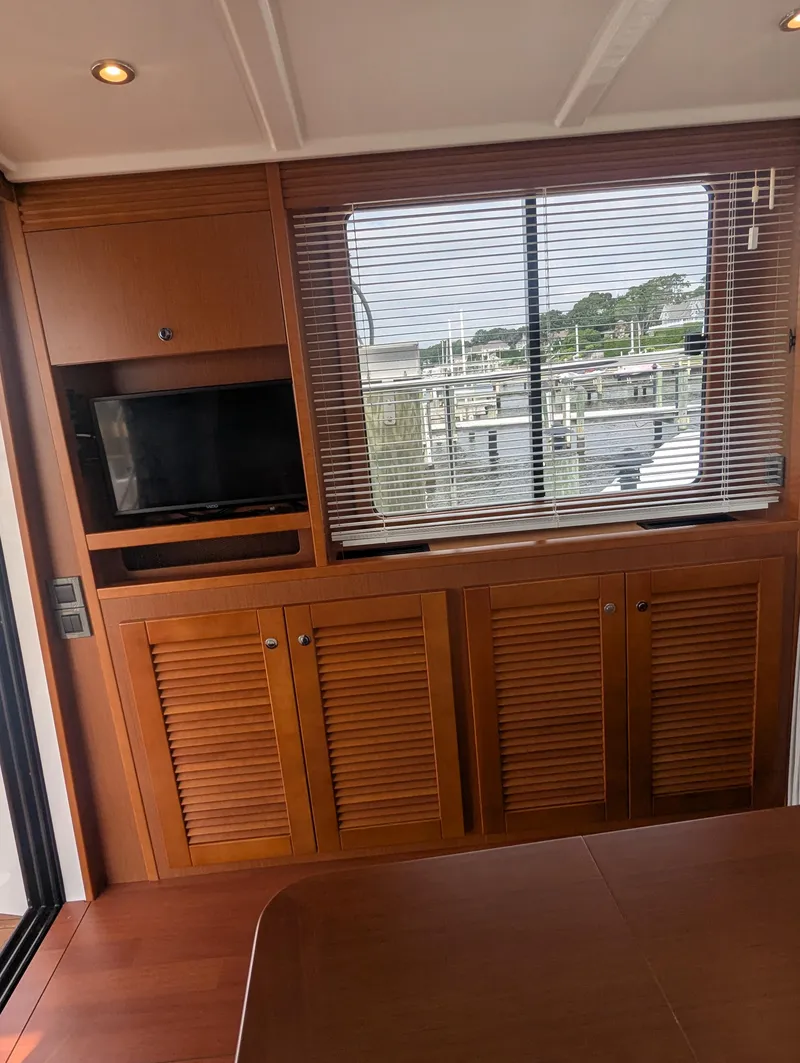 Slide: The Image of Interior of 2019 Beneteau Swift Trawler 44 with wooden cabinetry and window blinds. - 20