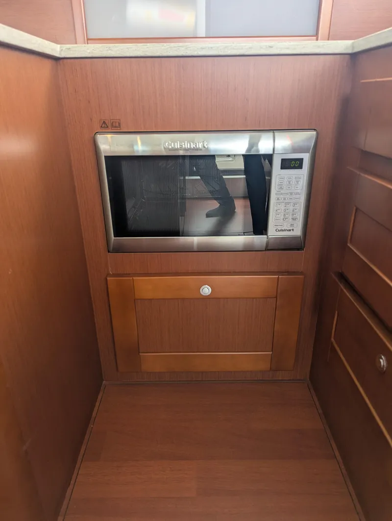 Slide: The Image of Microwave in 2019 Beneteau Swift Trawler 44 kitchen with wooden cabinetry. - 26