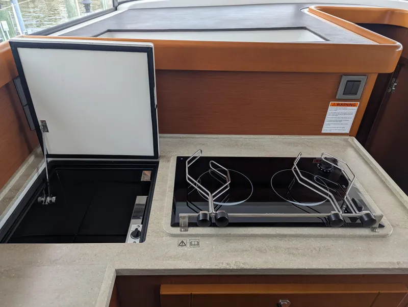 Slide: The Image of 2019 Beneteau Swift Trawler 44 kitchen with stove and storage compartment. - 27