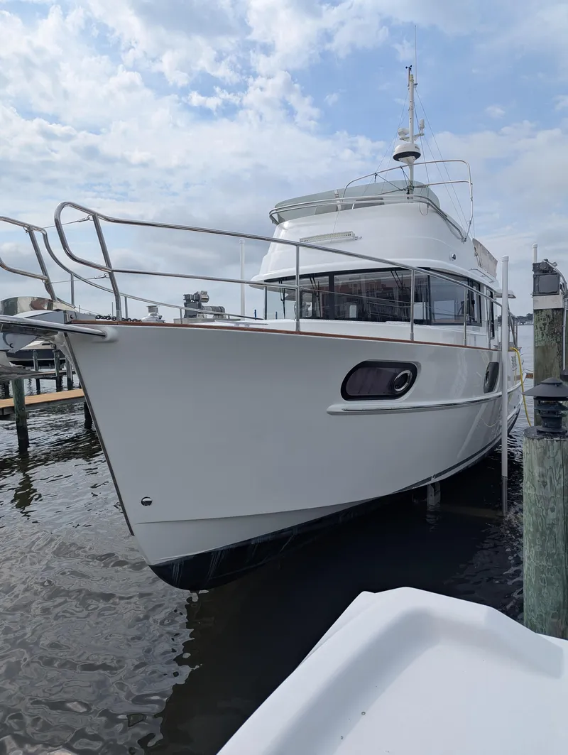 Slide: The Image of 2019 Beneteau Swift Trawler 44 docked at marina under cloudy sky. - 3