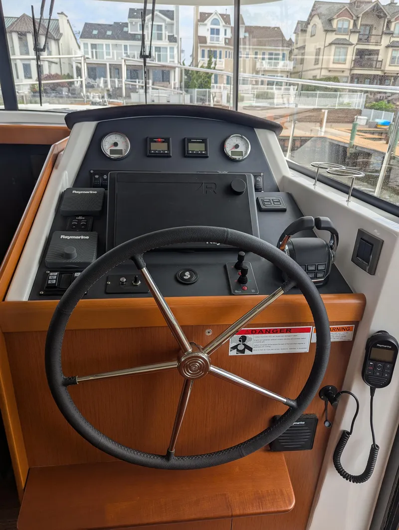 Slide: The Image of Helm of 2019 Beneteau Swift Trawler 44 with navigation controls and steering wheel. - 37