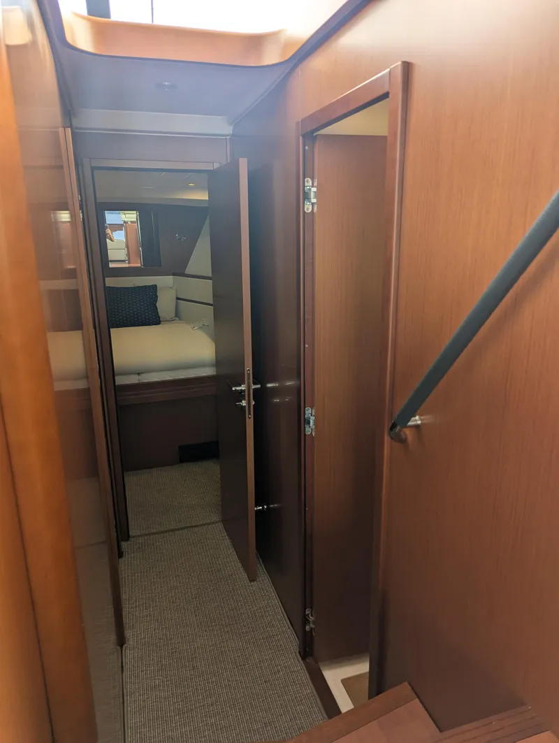 Slide: The Image of Interior hallway of 2019 Beneteau Swift Trawler 44, featuring wood paneling and bedroom view. - 38