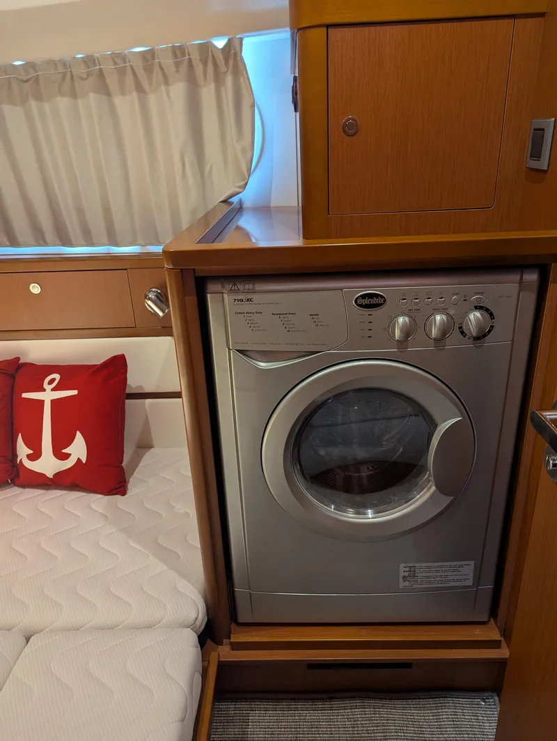 Slide: The Image of 2019 Beneteau Swift Trawler 44 interior with washing machine and nautical-themed decor. - 41
