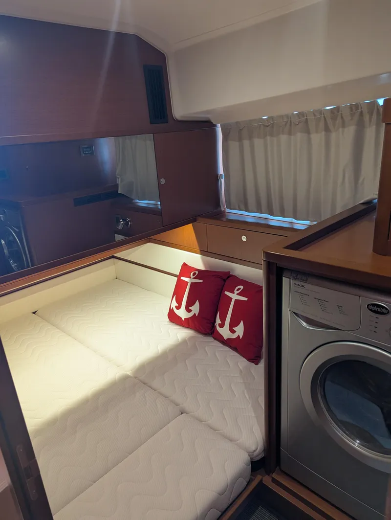Slide: The Image of Cozy cabin interior of 2019 Beneteau Swift Trawler 44 with anchor-themed pillows and washing machine. - 43